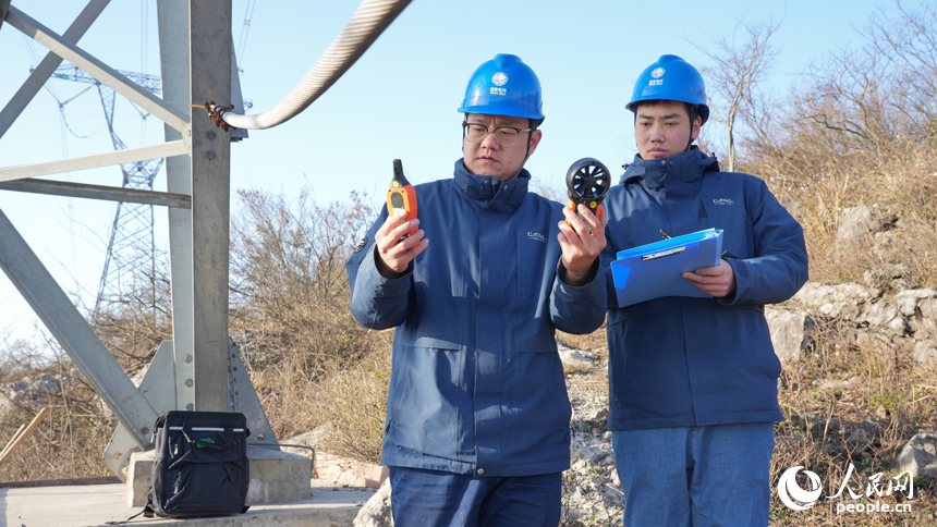江西送變電公司輸電運檢分公司九江巡檢站檢修人員利用專業儀器對鐵塔所在地的溫度和濕度進行數據監測。人民網 孔文進攝