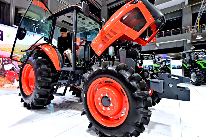 農戶在咨詢選購拖拉機、插秧機等農機產品。人民網 朱海鵬攝