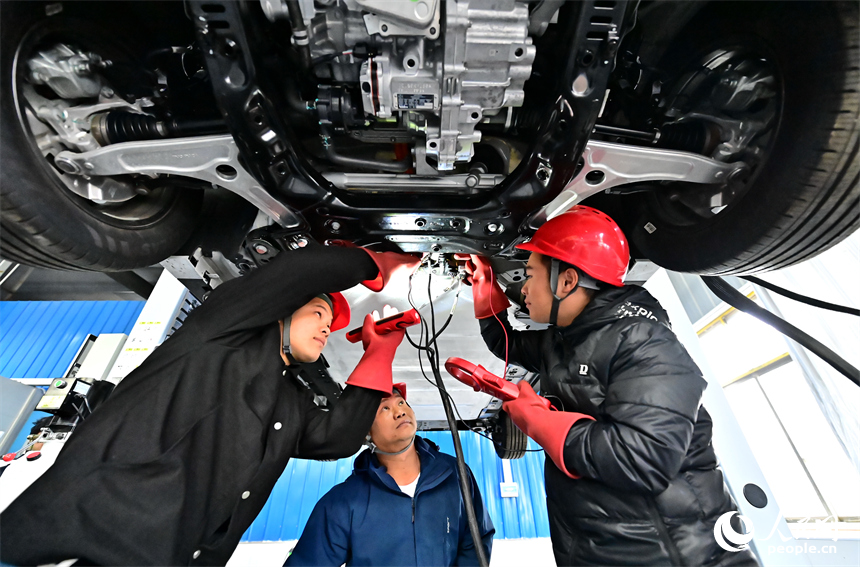 新能源汽車運維專業學生在老師的指導下學習新能源汽車電池包檢修技術。人民網 朱海鵬攝