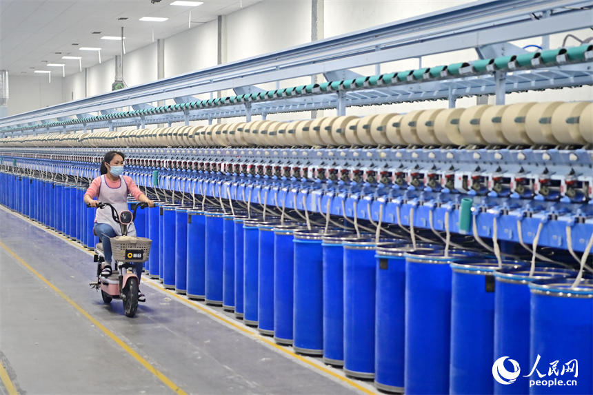 上高縣工業園區的一家民營紡織企業車間內，工人在智能紡紗生產線上加工出口訂單產品。人民網 朱海鵬攝