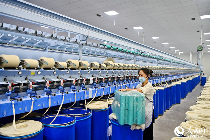 上高縣工業園區的一家民營紡織企業車間內，工人在智能紡紗生產線上加工出口訂單產品。人民網 朱海鵬攝