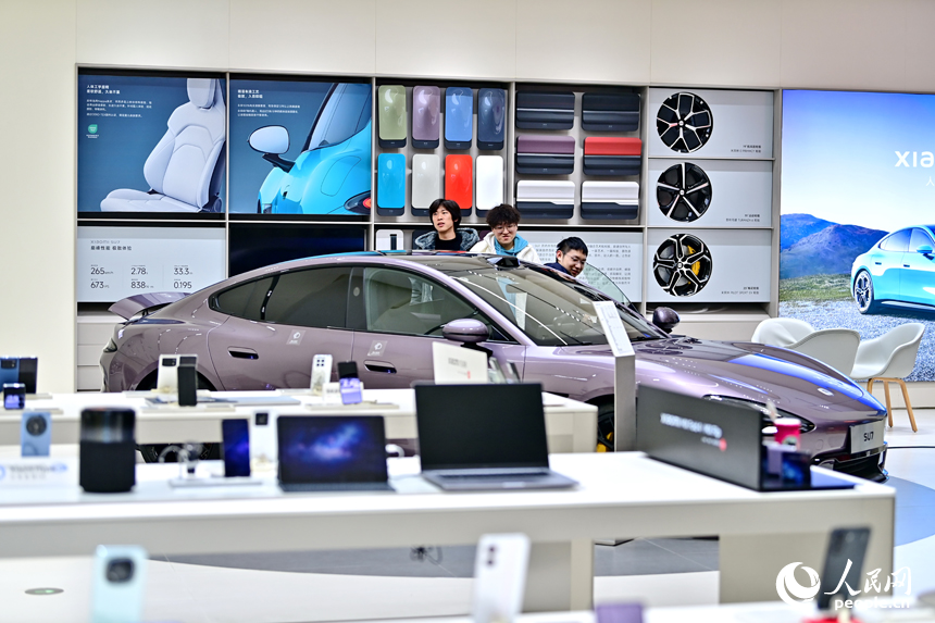 南昌市紅谷灘區的一家大型商場的汽車展示銷售區，不少顧客咨詢選購新能源汽車。人民網 朱海鵬攝