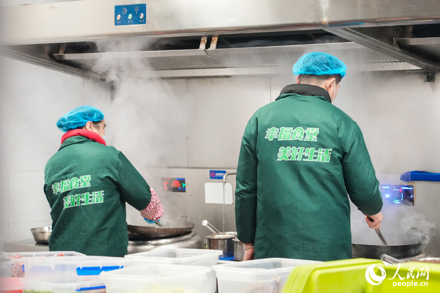 江西省南昌市東湖區光明社區幸福食堂，廚師正在烹飪菜肴。人民網 孔文進攝