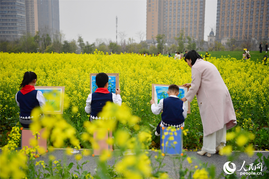 老師在花海中指導學生作畫，描繪春天的顏色。人民網記者 時雨攝