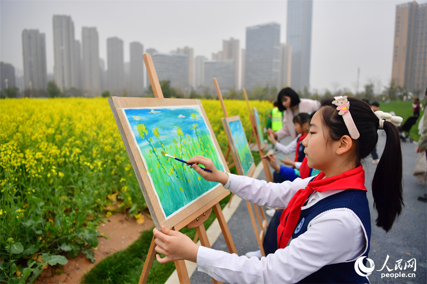 學生在花海中作畫，描繪春天的顏色。人民網記者 時雨攝