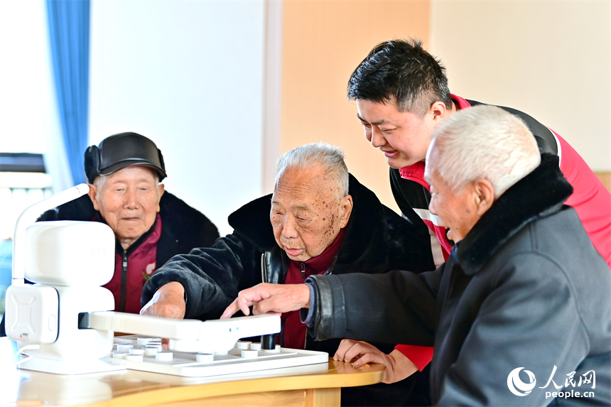 贛州市南康區蟠桃園老年公寓，男護工在教老人與智能機器人下象棋。人民網 朱海鵬攝