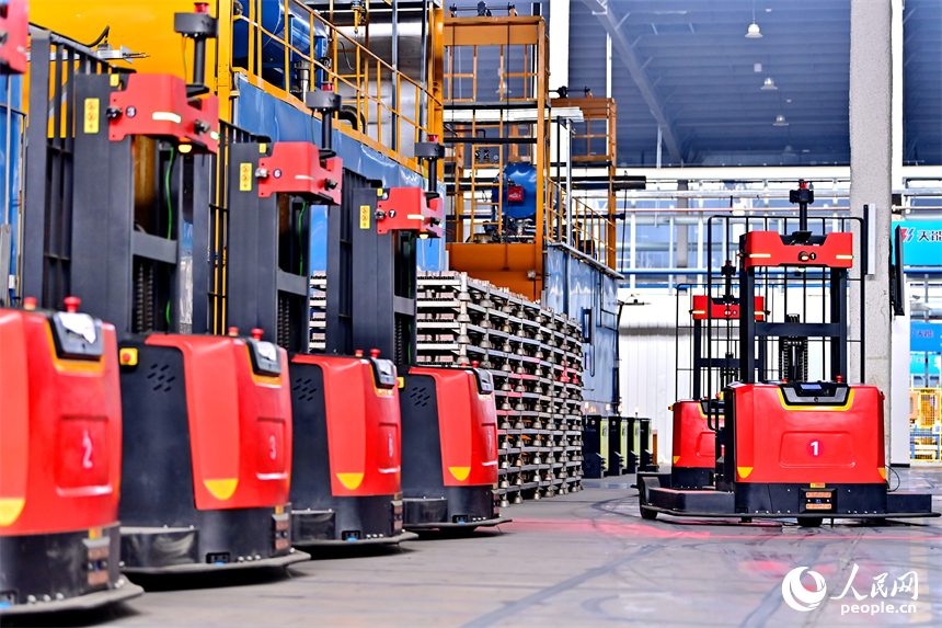 贛州市信豐縣的一家電動自行車蓄電池生產企業智能制造車間內，自動導引車來回作業。人民網 朱海鵬攝