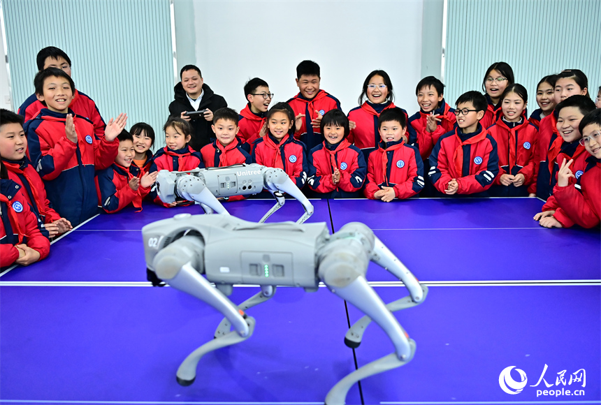 撫州市臨川區第五實驗學校人工智能科技小課堂上，學生在觀看仿生四足機器人表演。人民網 朱海鵬攝