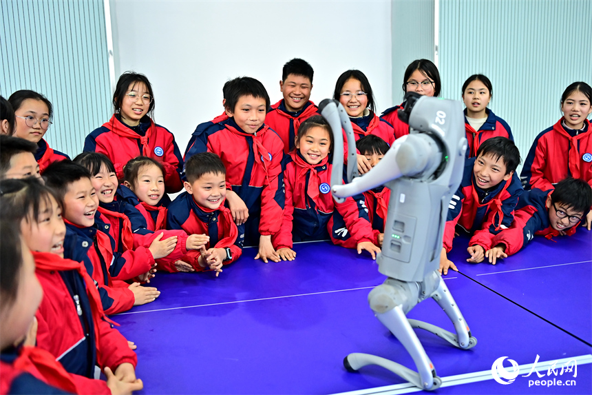 撫州市臨川區第五實驗學校人工智能科技小課堂上，學生在觀看仿生四足機器人表演。人民網 朱海鵬攝