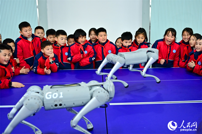 撫州市臨川區第五實驗學校人工智能科技小課堂上，學生在觀看仿生四足機器人表演。人民網 朱海鵬攝