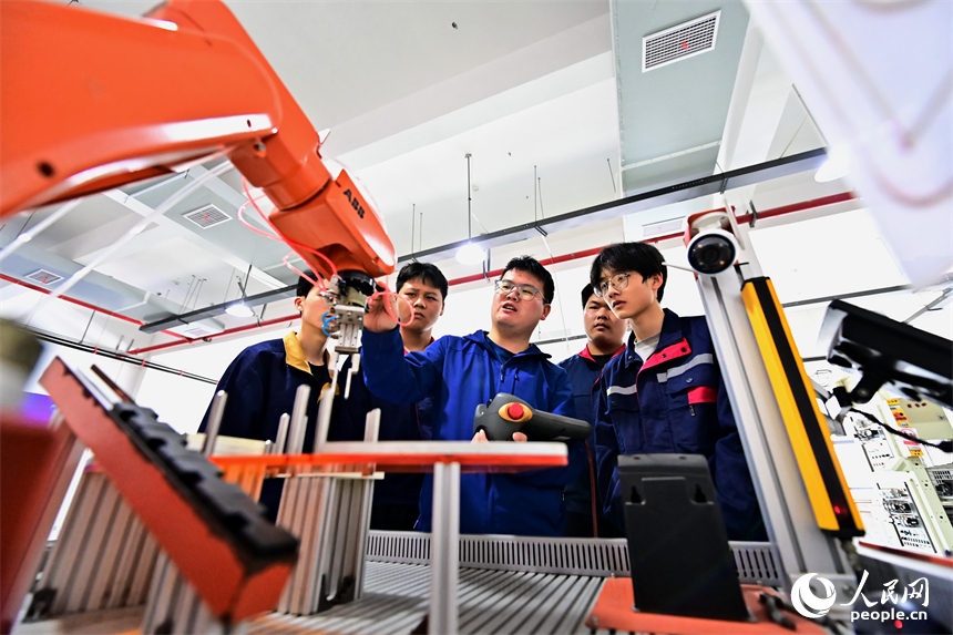 上饒市弋陽中等職業學校工業機器人實訓基地，學生在學習智能機械臂操作技能和編程知識。人民網 朱海鵬攝