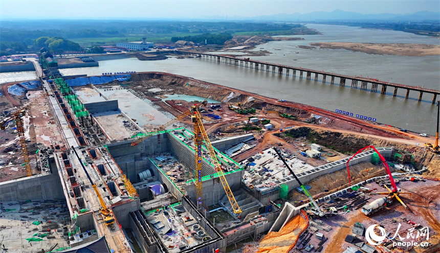 撫州市金溪縣滸灣鎮，疏山水利樞紐工程施工現場塔吊林立，工人在建設樞紐水閘和大壩。人民網 朱海鵬攝