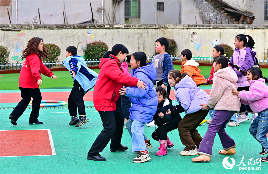 撫州市樂安縣龔坊鎮南邊村“幼吾幼”少兒之家，當地慈善總會的志愿者在和農村留守兒童一起交流互動，開展戶外健身游戲。人民網 朱海鵬攝