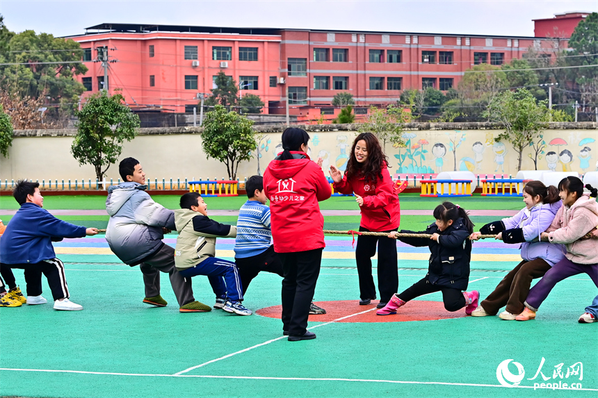 撫州市樂安縣龔坊鎮南邊村“幼吾幼”少兒之家，當地慈善總會的志愿者在和農村留守兒童一起交流互動，開展戶外健身游戲。人民網 朱海鵬攝