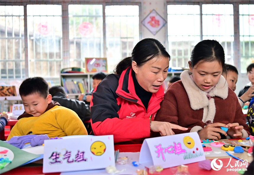 撫州市樂安縣湖溪鄉梅溪村“幼吾幼”少兒之家，當地慈善總會的志愿者和農村留守兒童一起交流互動，進行趣味粘土手工制作游戲。人民網 朱海鵬攝
