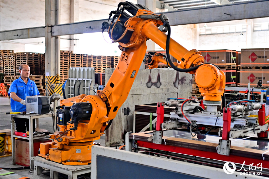 豐城市的一家陶瓷有限公司智能化生產車間，工人在操作工業機器人加工陶瓷產品。人民網 朱海鵬攝