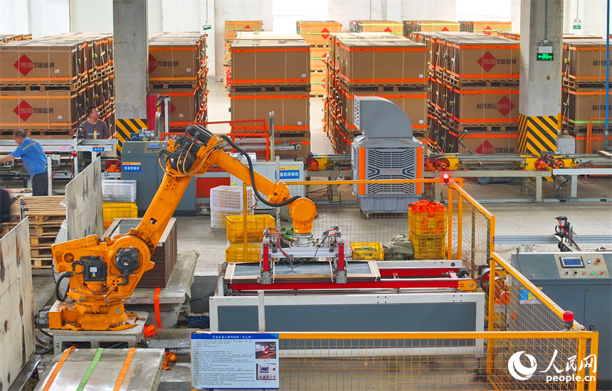 豐城市的一家陶瓷有限公司智能化生產車間，工人在操作工業機器人加工陶瓷產品。人民網 朱海鵬攝