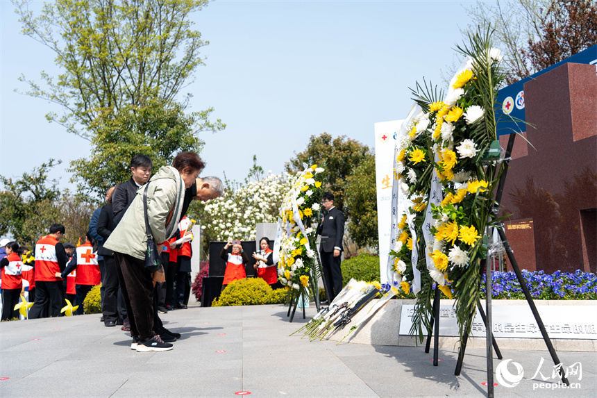 活動現場，嘉賓與家屬依次敬獻鮮花。人民網 龍楚良攝