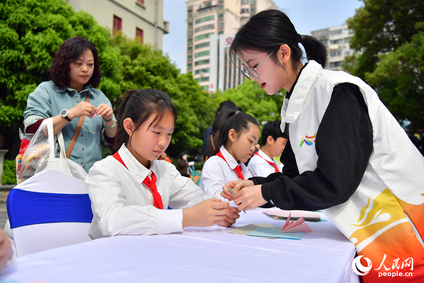 志愿者協助小朋友手折玉蘭花。人民網記者 時雨攝