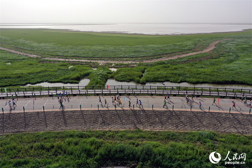 2025江西永修半程馬拉松賽鳴槍開跑，選手們奔跑在鄱陽湖“最美水上公路”賽道上。人民網記者 時雨攝