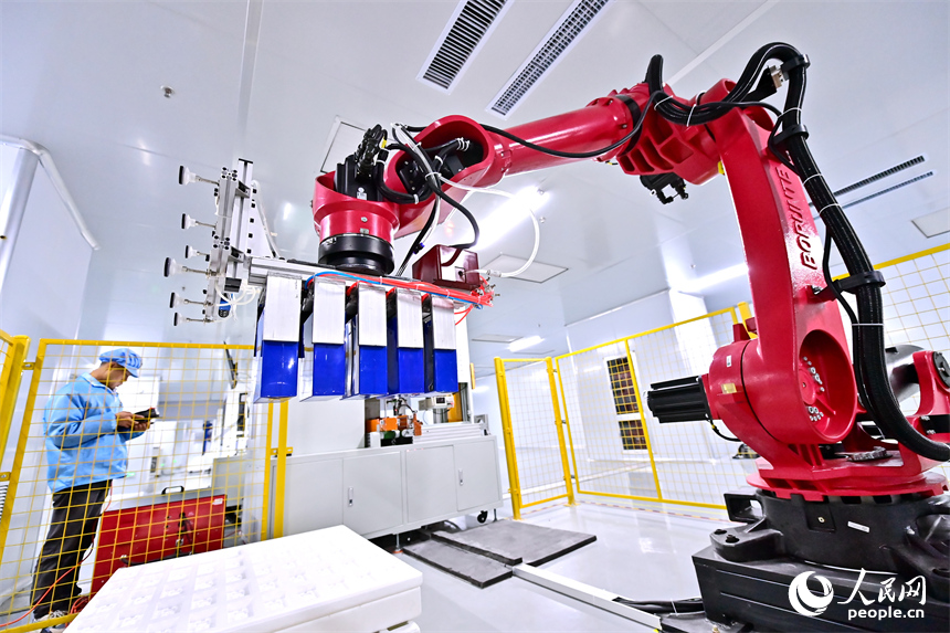 上饒市弋陽縣高新技術產業園區的科技企業車間內，工人在操作智能機械臂加工新能源汽車零部件。人民網 朱海鵬攝