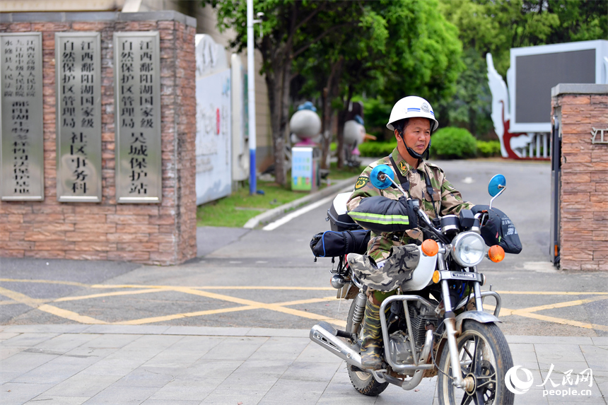 王小龍騎著摩托車，帶著望遠鏡前往鄱陽湖湖區巡護。人民網記者 時雨攝