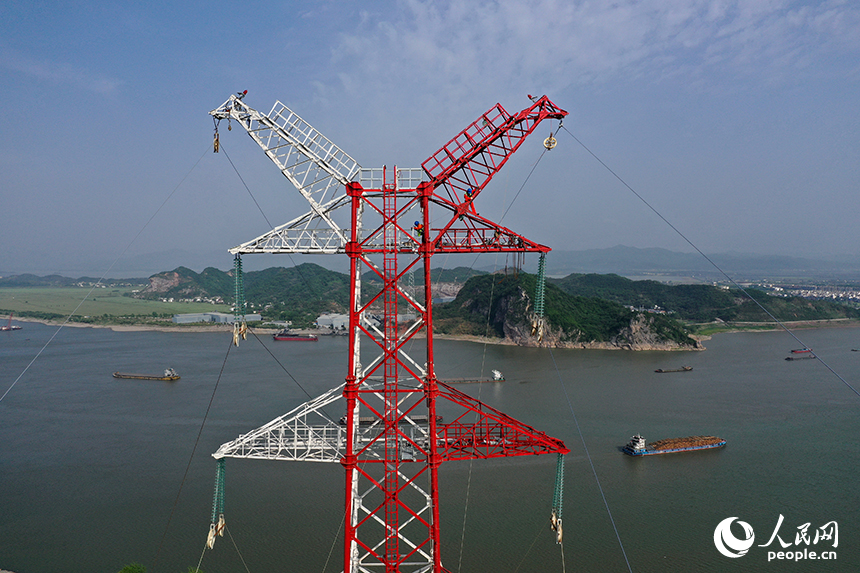 國家電網江西送變電中建公司施工人員正在電力鐵塔塔頂作業。人民網記者 時雨攝