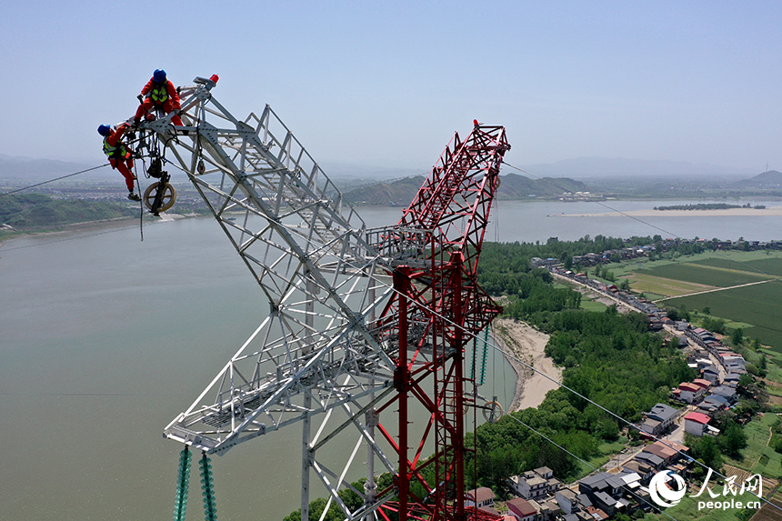 國家電網江西送變電中建公司施工人員正在電力鐵塔塔頂作業。人民網記者 時雨攝