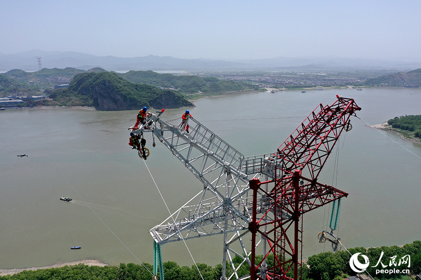 國家電網江西送變電中建公司施工人員正在電力鐵塔塔頂作業。人民網記者 時雨攝