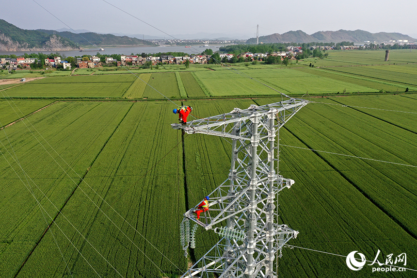 國家電網江西送變電中建公司施工人員正在電力鐵塔塔頂作業。人民網記者 時雨攝