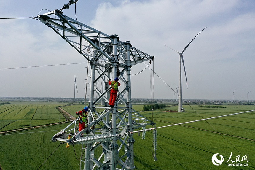 國家電網江西送變電中建公司施工人員正在電力鐵塔塔頂作業。人民網記者 時雨攝