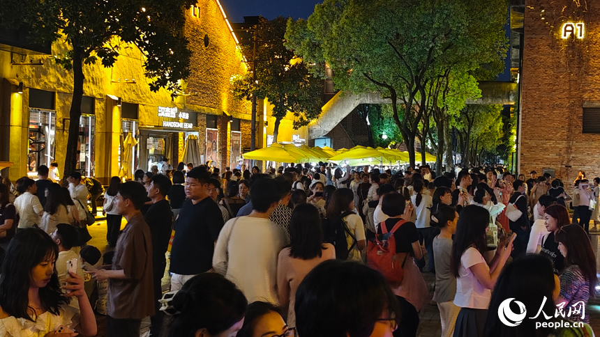 在陶溪川夜市，熙熙攘攘的人群穿梭于五百余攤位間，煙火氣與藝術氛圍升騰，繪就一幅熱鬧非凡的市井長卷。人民網 涂詩軒攝