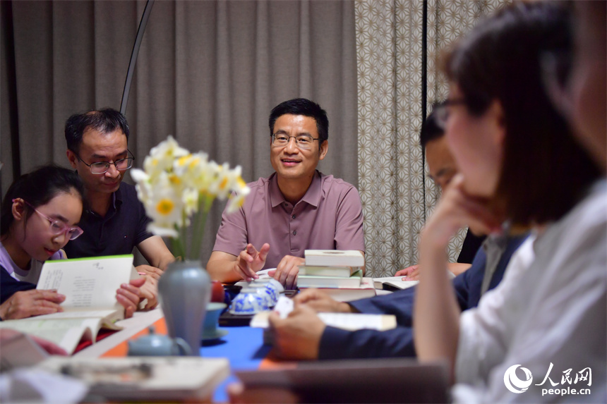 每晚七點半，讀書會成員圍坐在一起共同看書、探討，分享知識和快樂。人民網記者 時雨攝