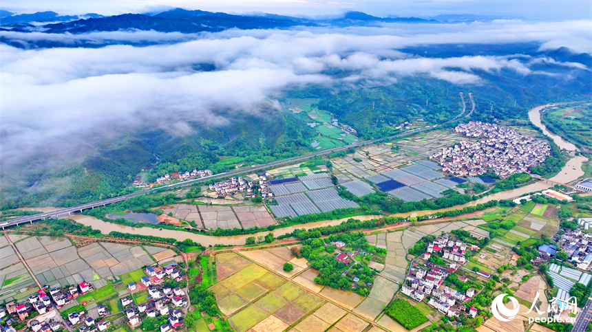贛州市大余縣黃龍鎮葉敦村，寬闊的鄉村公路與蜿蜒河流、連綿青山相映成景。人民網 朱海鵬攝