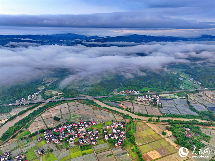 贛州市大余縣黃龍鎮葉敦村，寬闊的鄉村公路與蜿蜒河流、連綿青山相映成景。人民網 朱海鵬攝