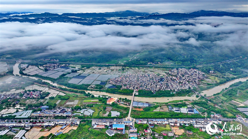 贛州市大余縣黃龍鎮葉敦村，寬闊的鄉村公路與蜿蜒河流、連綿青山相映成景。人民網 朱海鵬攝