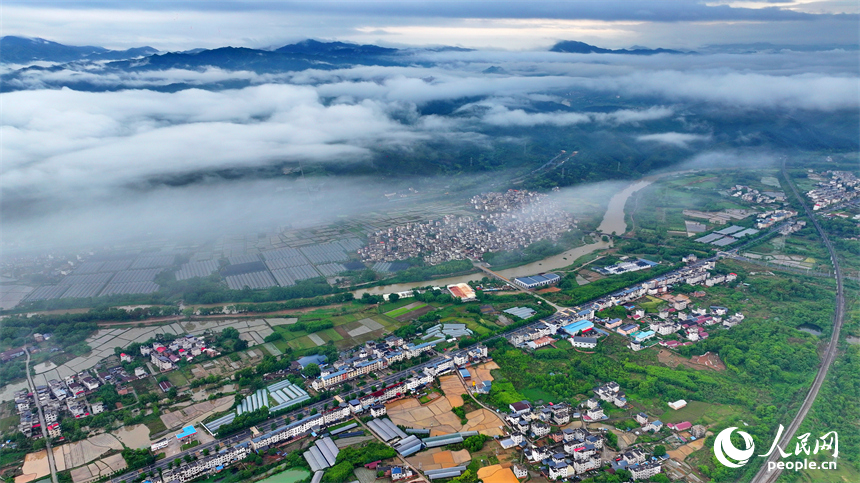 贛州市大余縣黃龍鎮葉敦村，寬闊的鄉村公路與蜿蜒河流、連綿青山相映成景。人民網 朱海鵬攝