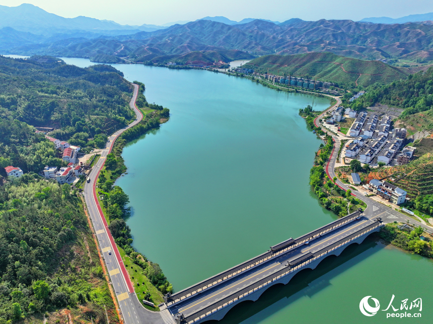 贛州市上猶縣東山鎮，車輛在環湖公路行駛，沿線水清岸綠景美春意濃。人民網 朱海鵬攝