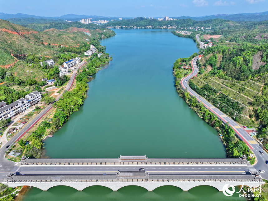 贛州市上猶縣東山鎮，車輛在環湖公路行駛，沿線水清岸綠景美春意濃。人民網 朱海鵬攝