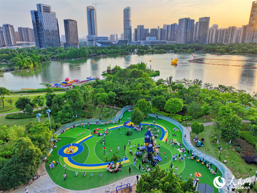 贛州市中心城區的一處公園里，家長帶著孩子在兒童游樂園內游玩，樂享親子時光。人民網 朱海鵬攝