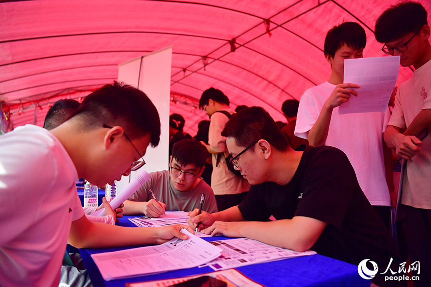“國聘行動”現場，高校畢業生正在填寫求職材料。人民網記者 時雨攝