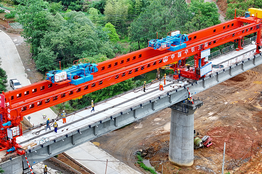 瑞金市澤覃鄉，大型架梁機平穩前移，工人在架設瑞梅鐵路橋梁。人民網 朱海鵬攝