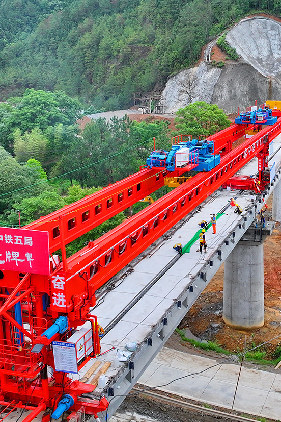 瑞金市澤覃鄉，大型架梁機平穩前移，工人在架設瑞梅鐵路橋梁。人民網 朱海鵬攝