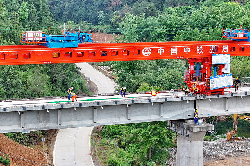 瑞金市澤覃鄉，大型架梁機平穩前移，工人在架設瑞梅鐵路橋梁。人民網 朱海鵬攝