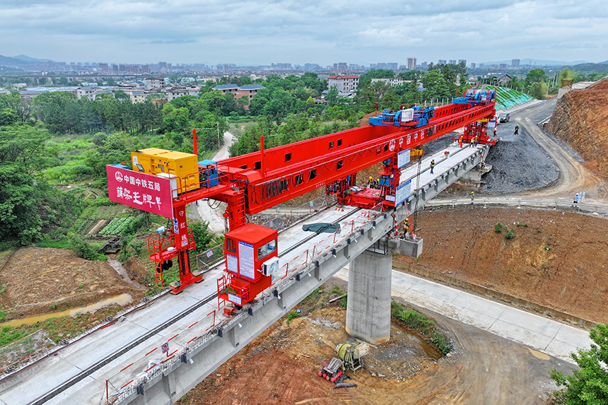 瑞金市澤覃鄉，大型架梁機平穩前移，工人在架設瑞梅鐵路橋梁。人民網 朱海鵬攝