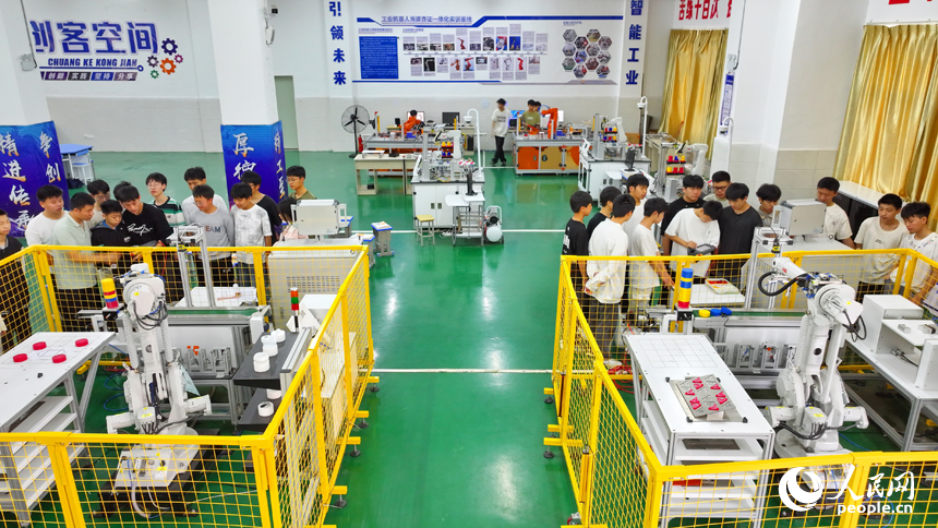 瑞金市瑞金中等專業學校工業機器人實訓基地，老師在指導學生在操作智能機械臂。人民網 朱海鵬攝