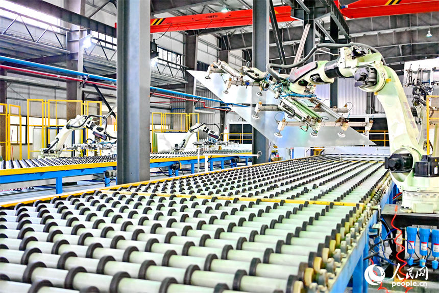 贛州市定南縣的一家新材料企業生產車間的智能機械臂有序運轉，工人在自動化產線上加工光伏玻璃。人民網 朱海鵬攝