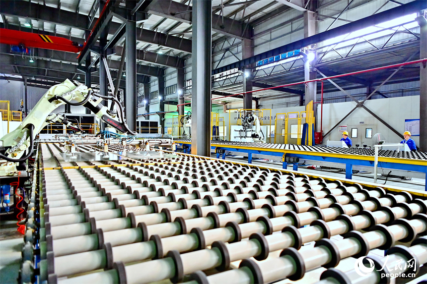 贛州市定南縣的一家新材料企業生產車間的智能機械臂有序運轉，工人在自動化產線上加工光伏玻璃。人民網 朱海鵬攝