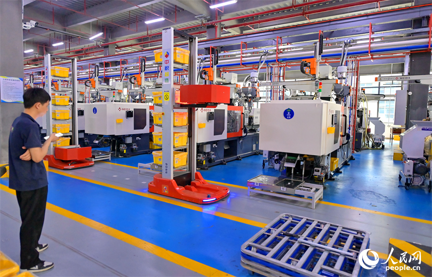 瑞金市經濟技術開發區5G數字產業園，智能自動導引車在車間里來回穿行運送生產物料。人民網 朱海鵬攝