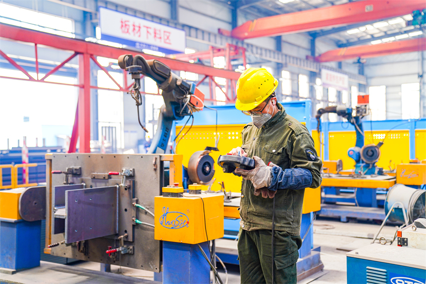 工人正在設置自動焊接機器人自動作業程序。郭昊攝